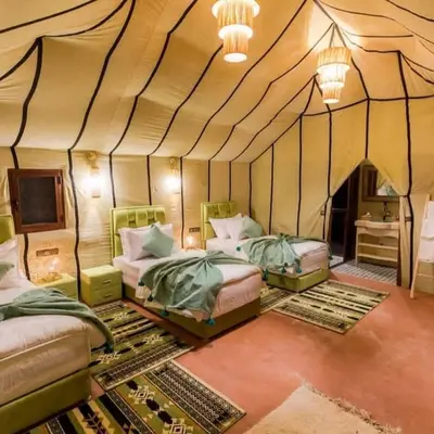 a room with three beds in a tent at Dream Desert Camp in Merzouga