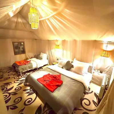 a bedroom with two beds with red clothes on them at Dream Desert Camp in Merzouga