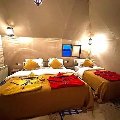 a bedroom with two beds in a room at Dream Desert Camp in Merzouga