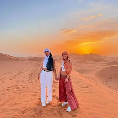 a man and a woman standing in the desert at Dream Desert Camp in Merzouga