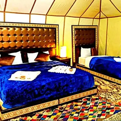 a bedroom with two beds in a tent at Dream Desert Camp in Merzouga