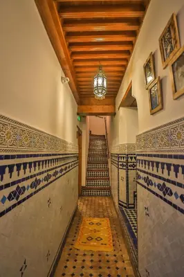 a staircase in a building with tile floors and a chandelier at Riad Fes la Mama - Rooftop in Fès