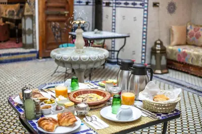 a table filled with breakfast foods and orange juice at Riad Fes la Mama - Rooftop in Fès