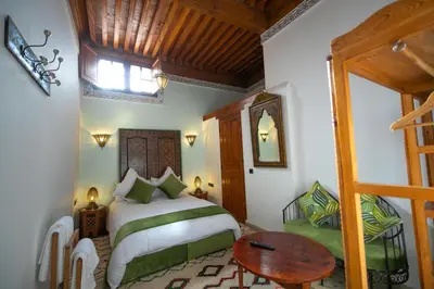 a bedroom with a bed and a table in a room at Riad Fes la Mama - Rooftop in Fès