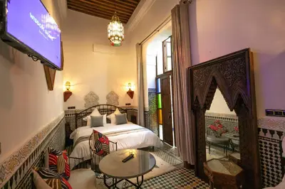 a hotel room with a bed and a tv at Riad Fes la Mama - Rooftop in Fès
