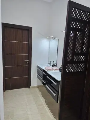 a bathroom with a vanity with a mirror and a door at Villa in Fès
