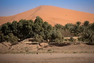 a soccer field in front of a sand dune at Authentic Sahara Desert Camps in Merzouga