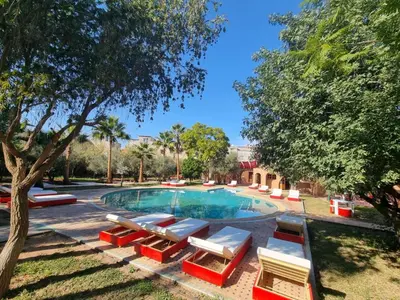 a swimming pool with lounge chairs and a tree at Dar Fatna Marrakech in Oulad Akkou