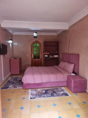 a bedroom with a large pink bed and a stool at Dar Fatna Marrakech in Oulad Akkou