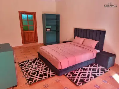 a bedroom with a large bed with a red blanket at Dar Fatna Marrakech in Oulad Akkou