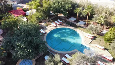 an overhead view of a swimming pool with chairs and trees at Dar Fatna Marrakech in Oulad Akkou