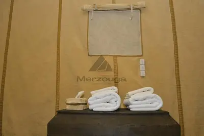 a pile of towels sitting on top of a table at Merzouga Luxurious Sahara Camps in Merzouga