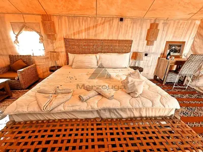 a bedroom with a large bed in a tent at Merzouga Luxurious Sahara Camps in Merzouga