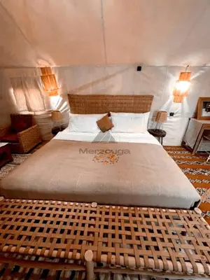 a bedroom with a large bed in a tent at Merzouga Luxurious Sahara Camps in Merzouga