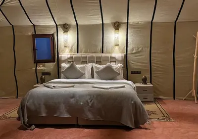 a bedroom with a large bed in a tent at Mystic Dunes Camp & desert activities in Merzouga