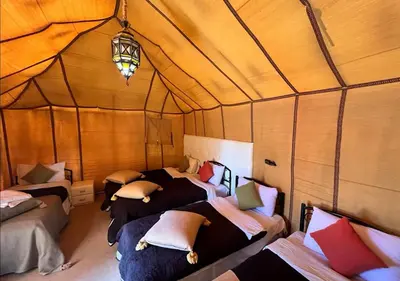 a room with four beds in a tent at Mystic Dunes Camp & desert activities in Merzouga