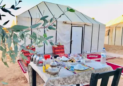 a table in front of a white tent at Mystic Dunes Camp & desert activities in Merzouga