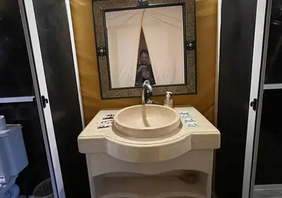a person taking a picture of a sink in a bathroom at Mystic Dunes Camp & desert activities in Merzouga