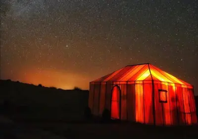 a red tent under a starry sky at night at Mystic Dunes Camp & desert activities in Merzouga