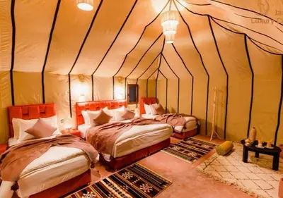 a bedroom with two beds in a tent at Merzouga Formidable camp in Merzouga