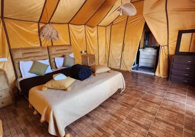 a bedroom with a bed in a tent at Merzouga Formidable camp in Merzouga