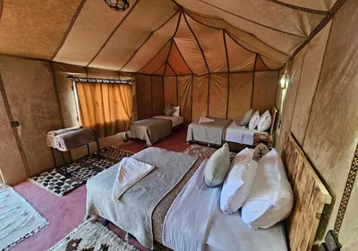 a bedroom with two beds in a tent at Merzouga Formidable camp in Merzouga