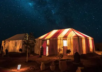 a large tent under a starry sky at night at Merzouga Formidable camp in Merzouga