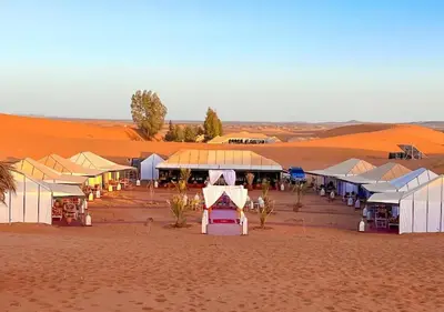 a group of tents in the middle of a desert at Merzouga Formidable camp in Merzouga