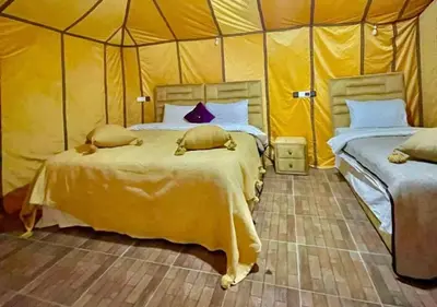 a bedroom with two beds in a tent at Merzouga Formidable camp in Merzouga