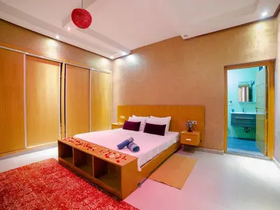 a bedroom with a large bed and a red rug at Villa privée & élégante avec piscine & jardin in Marrakech