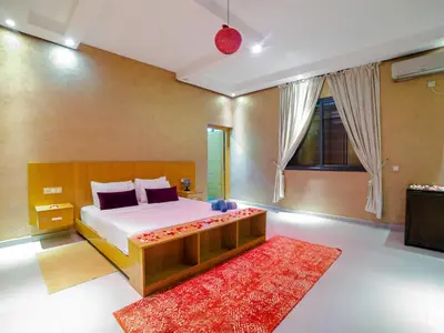 a bedroom with a large bed and a red rug at Villa privée & élégante avec piscine & jardin in Marrakech