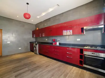 a kitchen with red cabinets and a washer at Villa privée & élégante avec piscine & jardin in Marrakech