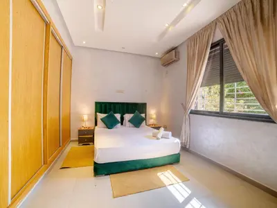 a bedroom with a large bed and a large window at Villa privée & élégante avec piscine & jardin in Marrakech