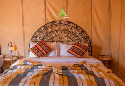 a bedroom with a large bed with aigil at Eco Desert Camp in Merzouga