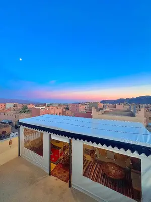 a view from the roof of a building with a blue awning at Riad Dar Sahara - Panoramic Rooftop in Nkob