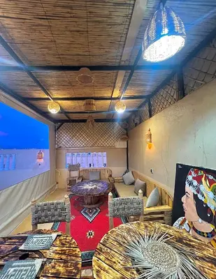 a living room with a couch and a table at Riad Dar Sahara - Panoramic Rooftop in Nkob
