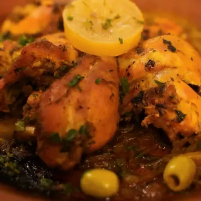 a plate of food with shrimp and a lemon at Aurea Duna Luxury Camp in Merzouga