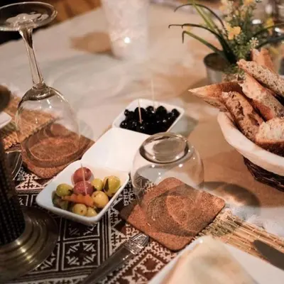 a table with a plate of food and wine glasses at Aurea Duna Luxury Camp in Merzouga