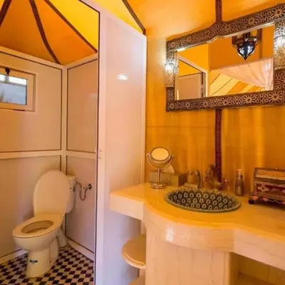 a bathroom with a toilet and a sink and a mirror at Aurea Duna Luxury Camp in Merzouga