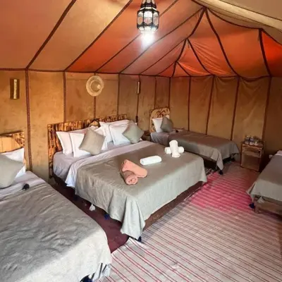 a bedroom with two beds in a tent at Aurea Duna Luxury Camp in Merzouga