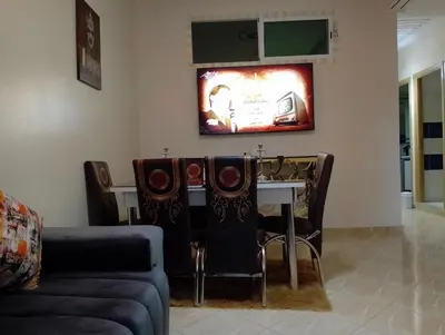 a living room with a table and a couch at Appartement lux in Fès