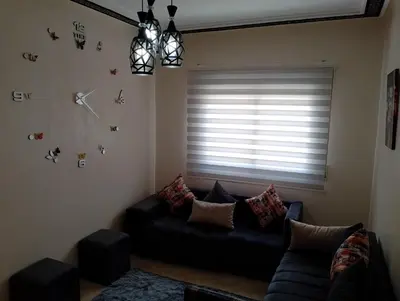 a living room with a couch and a window at Appartement lux in Fès