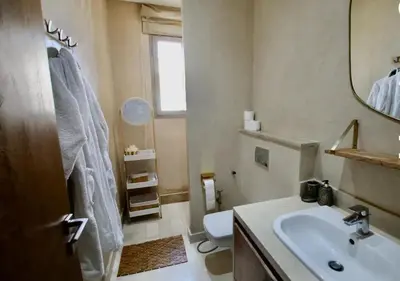 a bathroom with a sink and a toilet and a mirror at Sublime Villa Piscine & Jacuzzi in Marrakech