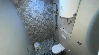 a small bathroom with a toilet and a shower at Tigemi in Fès