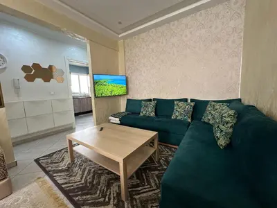 a living room with a green couch and a table at Tigemi in Fès