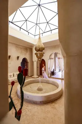 a large living room with a large fountain in the middle of a room at Dar des gazelles kech in Oulad Abbou