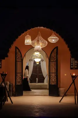 a woman standing in front of a doorway with chandeliers at Dar des gazelles kech in Oulad Abbou