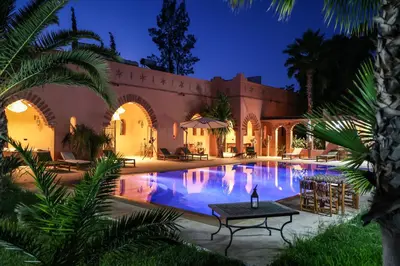 a villa with a swimming pool at night at Dar des gazelles kech in Oulad Abbou