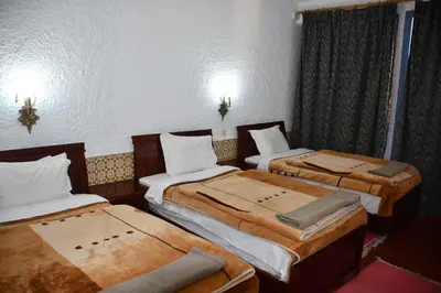 a room with three beds in a room at Hôtel Rose Mgouna in Kalaat MGouna