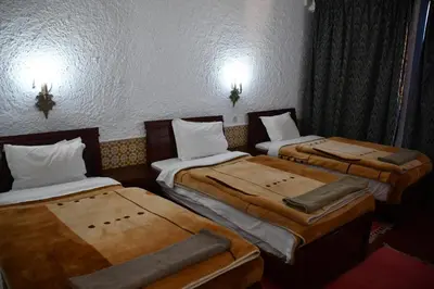 a room with three beds sitting next to each other at Hôtel Rose Mgouna in Kalaat MGouna